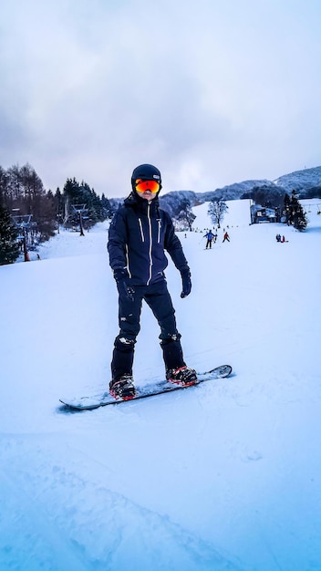 Foto ein mann in voller länge, der auf schnee ski fährt