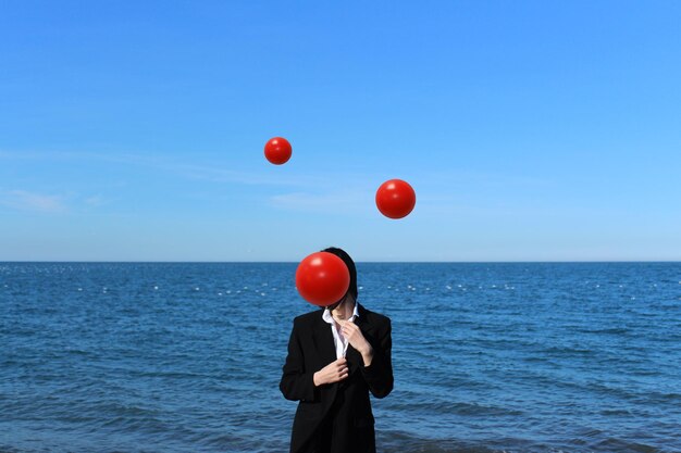 Foto ein mann in voller länge steht am meer an einem blauen himmel.