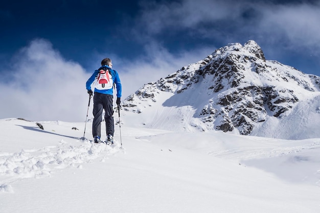 Ein Mann in voller Länge steht auf einer schneebedeckten Landschaft.
