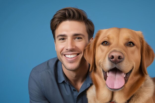 Ein Mann lächelt neben seinem Hund auf einem blauen Hintergrund im Studio