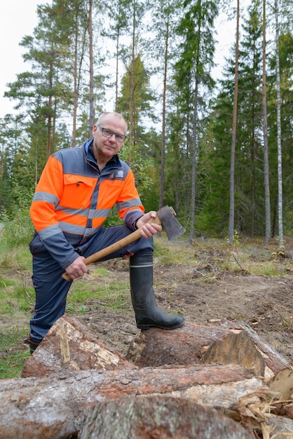 Foto ein mann lächelt, während er auf dem land im wald steht