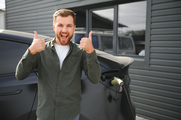 Foto ein mann lädt sein modernes elektroauto auf das konzept der grünen energie