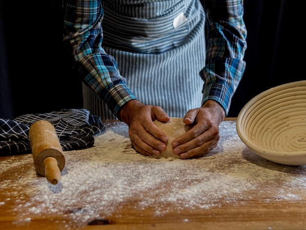 ein Mann macht Brot in einer Küche mit einem Holzbrett mit einer großen weißen Schüssel darauf