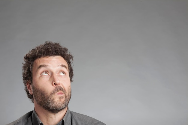 Ein Mann macht ein Gesicht vor einem grauen Hintergrund