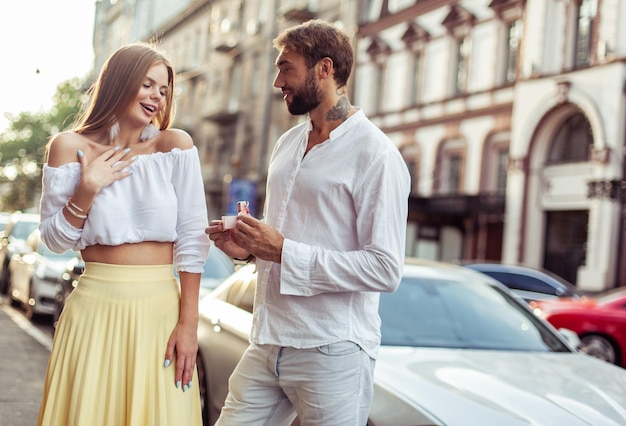 Ein Mann macht einen Heiratsantrag und gibt seiner geliebten Frau eine Geschenkkiste mit einem Ring in der Stadt