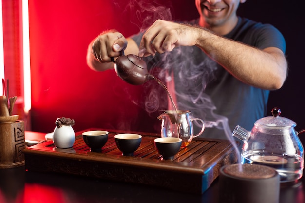 Ein Mann macht Tee an einem Teetisch mit Geräten nach traditioneller chinesischer Tradition