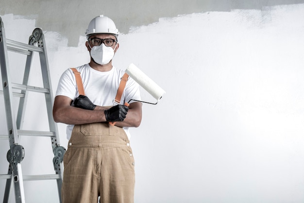 Ein Mann malt mit einer Rolle eine weiße Wand. Reparatur des Innenraums.