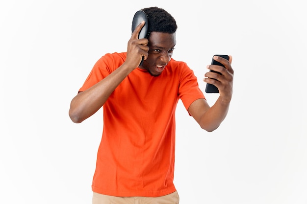 Ein Mann mit afrikanischem Aussehen kämmt seinen Kopf mit einem Telefon