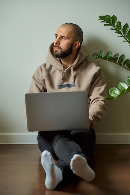 Ein Mann mit Bart arbeitet an seinem Laptop