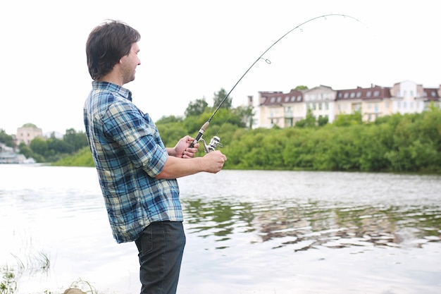 Ein Mann mit Bart fischt im Fluss zum Spinnfischen