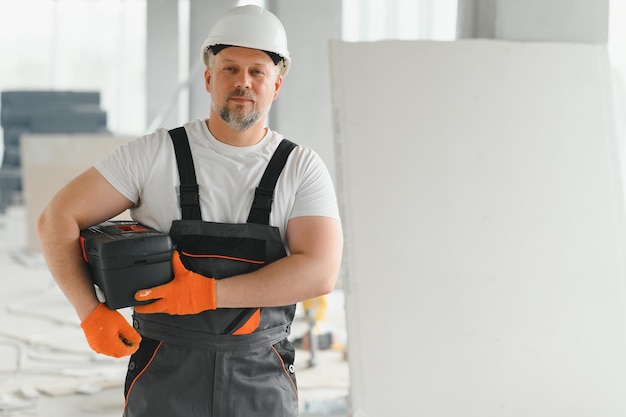 Ein Mann mit Bart in Helm und Arbeitskleidung Porträt eines Arbeiters in Arbeitsbekleidung mit Kopierfläche