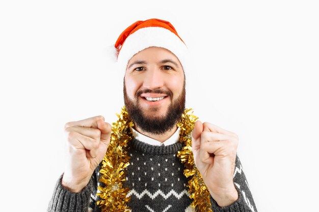 Ein Mann mit einem Bart in einer Weihnachtsmannmütze, die Weihnachtskugeln hält