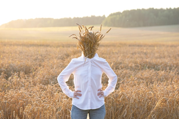 Ein Mann mit einem Gesicht hinter Weizen in einem Feld versteckt Das Konzept der Depersonalisierung Soft-Fokus