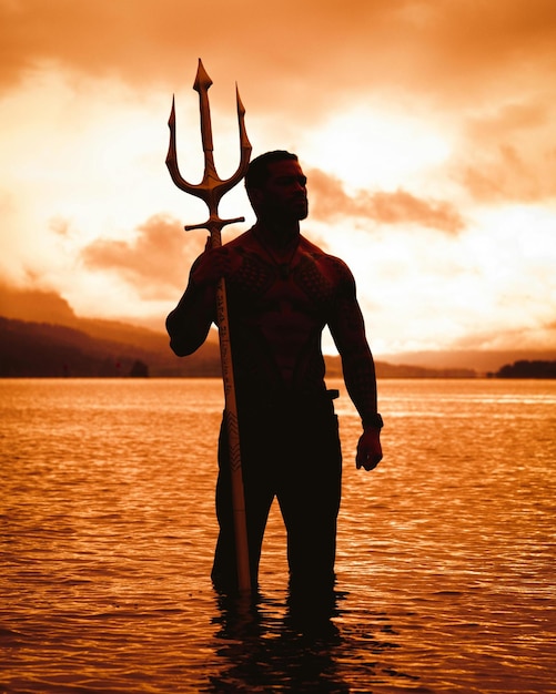 ein Mann mit einem großen Horn steht im Wasser mit einem Pfeil auf der Brust