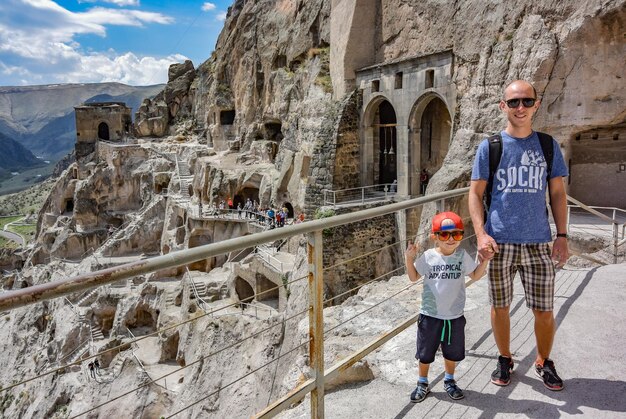 Ein Mann mit einem Kind mit Blick auf die Höhlenstadt Vardzia Höhlenkloster in Südgeorgien April 2019 Georgien