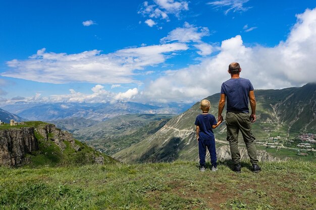 Ein Mann mit einem Kind vor dem Hintergrund einer Aussicht auf das Matlas-Plateau Khunzakhsky Bezirk Dagestan Russland 2021