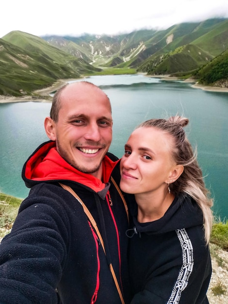 Ein Mann mit einem Mädchen auf dem Hintergrund des Kezenoyam-Sees im Kaukasus in Tschetschenien, Russland, Juni 2021