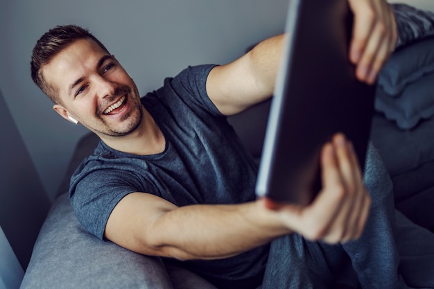 Ein Mann mit einem modernen Friseur macht ein Foto im Wohnzimmer