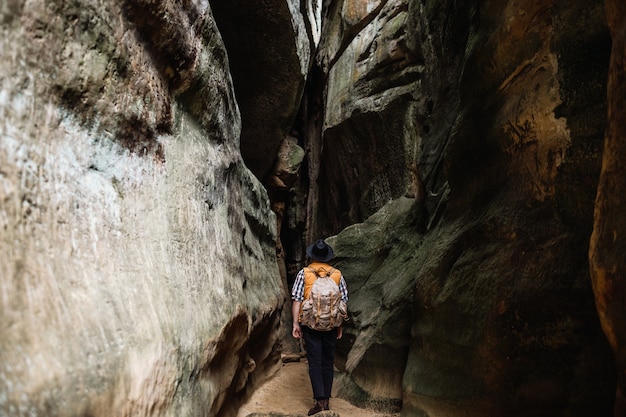 Ein Mann mit einem Rucksack geht eine Bergschlucht hinunter