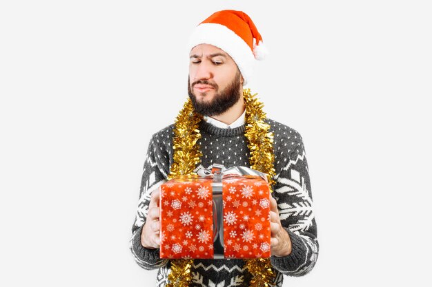 Foto ein mann mit einem weihnachtsgeschenk in seinen händen im studio auf einem weißen hintergrund