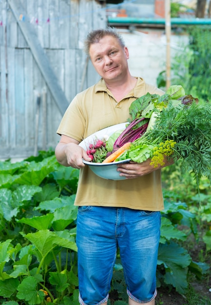 Foto ein mann mit einer gemüseernte im garten