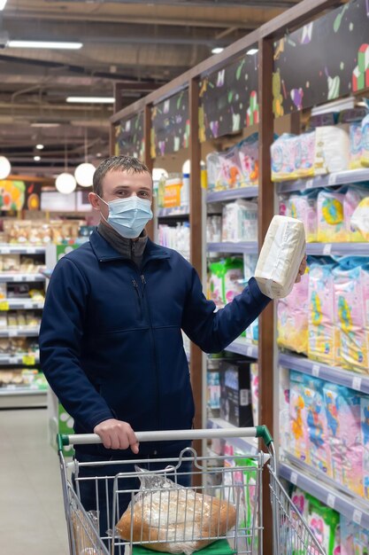 Ein Mann mit Einkaufskorb wählt Waren in einem Supermarkt aus Einzelhandel Quarantäne