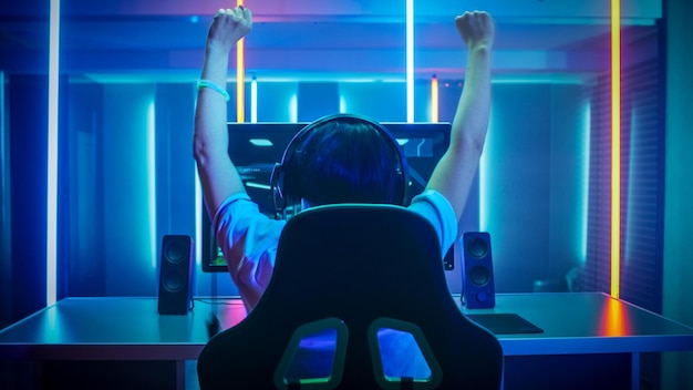 Ein Mann mit erhobenen Armen vor einem Computerbildschirm mit der Aufschrift „eSports“