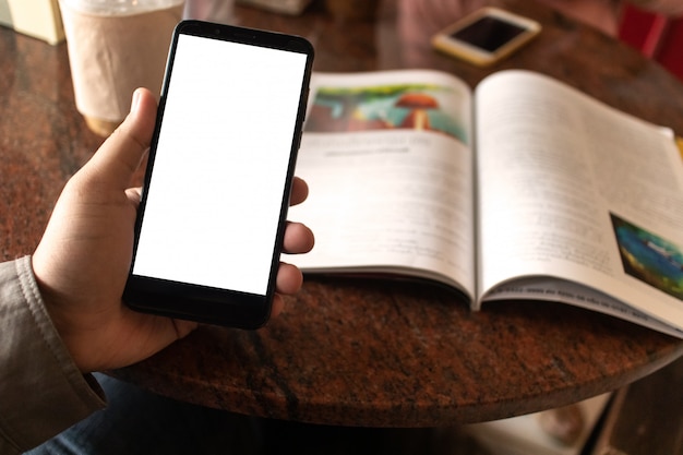 Foto ein mann öffnet die anwendung eines mobiltelefons in einem café.