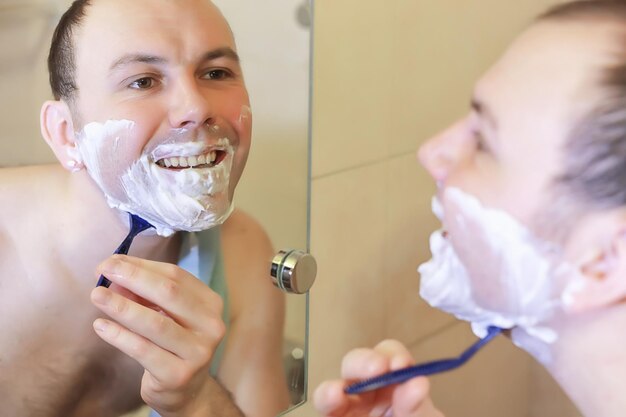 Ein Mann rasiert sich morgens vor der Arbeit im Badezimmer