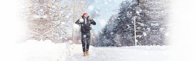 Ein Mann reist mit einem Rucksack. Winterwanderung im Wald. Tourist auf einem Spaziergang im Winter im Park.