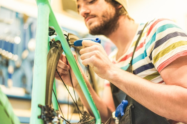 Foto ein mann repariert ein fahrrad in einer werkstatt