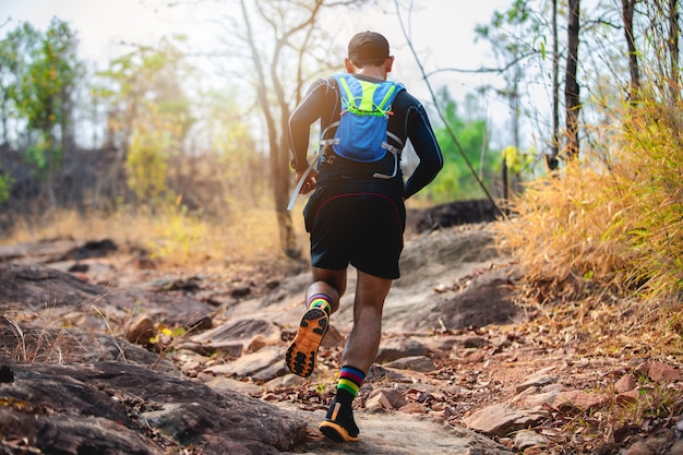 Ein mann runner of trail. und sportlerfüße mit sportschuhen für trailrunning im wald