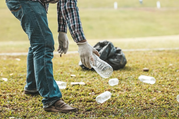 Ein Mann sammelt Müll in einem Park, der keinen Müll in den Müll wirft, kann die Schönheit des Gartenbereichs ruinieren und auch die globale Erwärmung verursachen und Tiere schädigen Konzept der Sauberkeit in öffentlichen Bereichen
