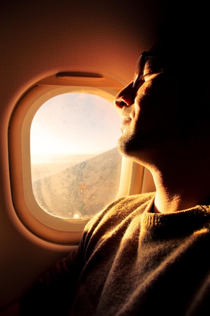 Foto ein mann schläft in einem flugzeug am fenster