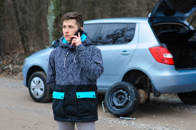 Ein Mann schlug ein Rad auf ein Auto und ruft den technischen Dienst an