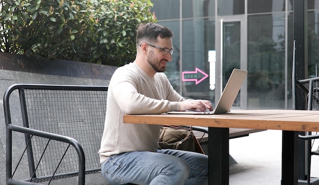 Ein Mann sitzt an einem Tisch mit einem Laptop und einem Schild mit der Aufschrift „Ich arbeite“.