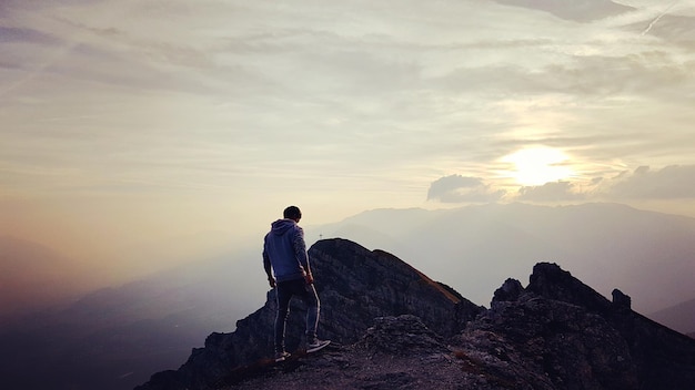Ein Mann sitzt auf einem Felsen gegen den Himmel