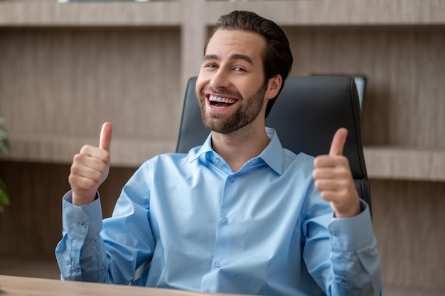 Ein Mann sitzt im Büro und sieht zufrieden aus