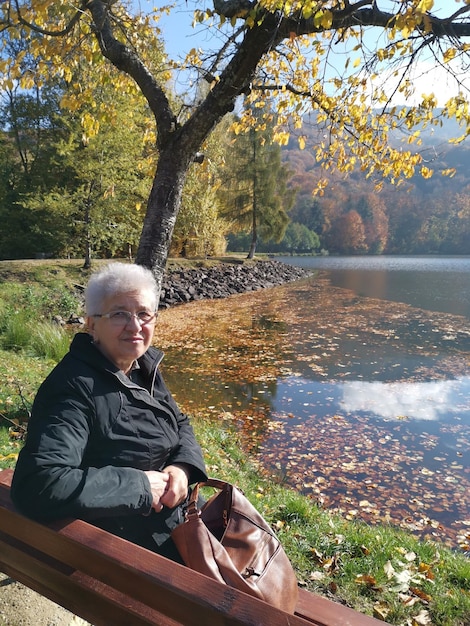 Foto ein mann sitzt im herbst am see