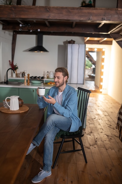 Ein Mann sitzt in seiner Küche und trinkt Tee