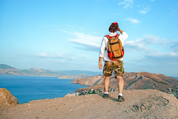 Ein Mann sitzt mit Blick auf einen Panoramablick auf eine wunderschöne Küste