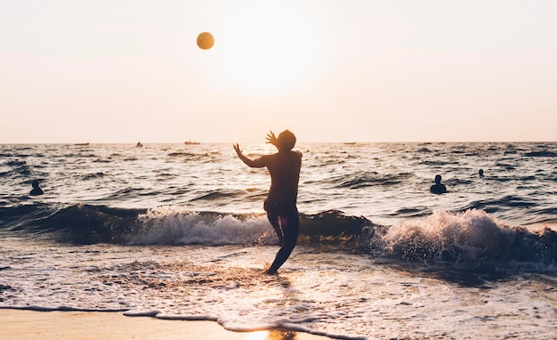 Foto ein mann spielt mit einem ball im meer gegen den himmel