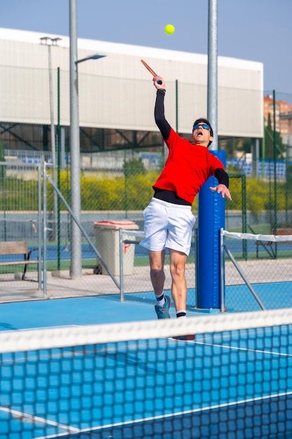 Ein Mann springt, um den Ball auf einem Pickleballplatz zu erreichen