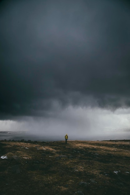 Ein Mann steht auf dem Feld gegen Sturmwolken