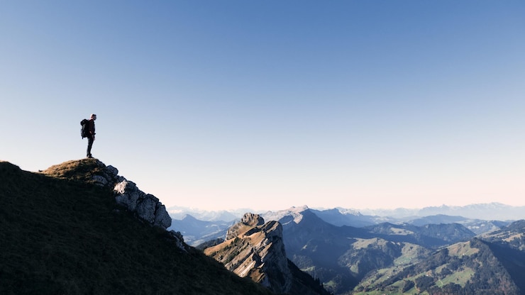 Foto ein mann steht auf einem berg vor klarem himmel