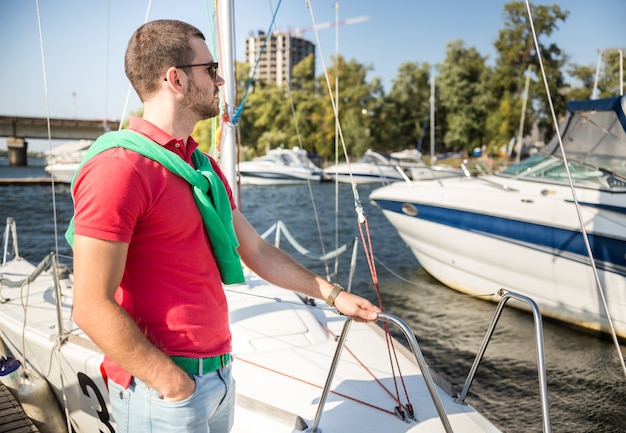 Ein Mann steht auf einem Boot und schaut in die Ferne.