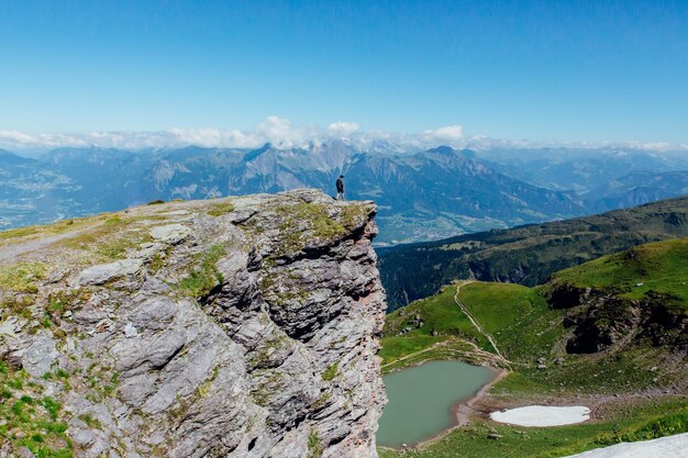 Foto ein mann steht auf einer klippe gegen berge