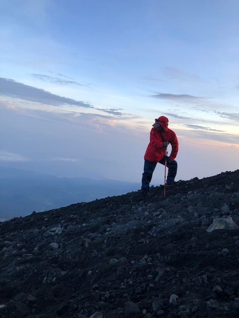 Foto ein mann steht bei sonnenuntergang auf einem felsen gegen den himmel