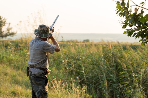 Ein Mann steht mit Waffen und Jagdhunden auf der Suche nach dem Wild