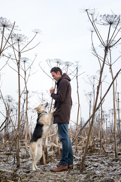 Foto ein mann steht neben einem hund an land